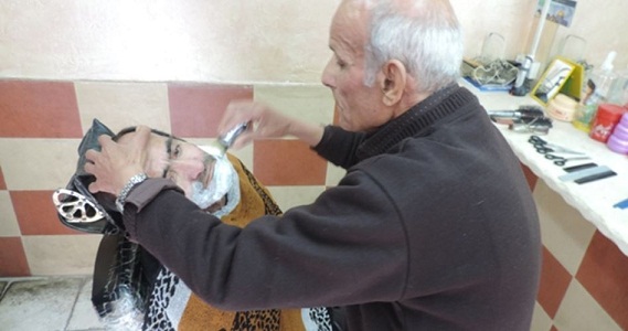 80-year-old Palestinian barber offers haircut and music