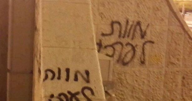 Israeli settlers spray racist graffiti, torch Palestinian vehicle